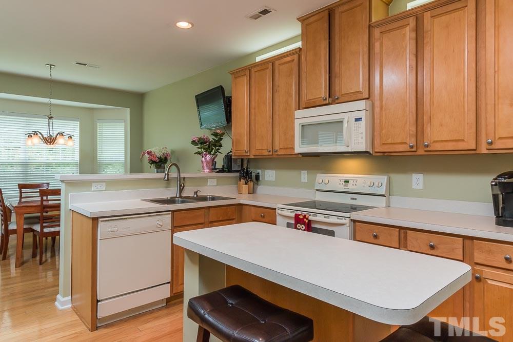 8437 Aztec Dawn Court Raleigh, NC 27613 - Photo 5 of 24 a kitchen with a stove a sink and a refrigerator