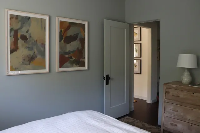 a bedroom with a bed and a painting on the wall