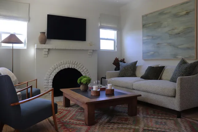 a living room with furniture a flat screen tv and a fireplace