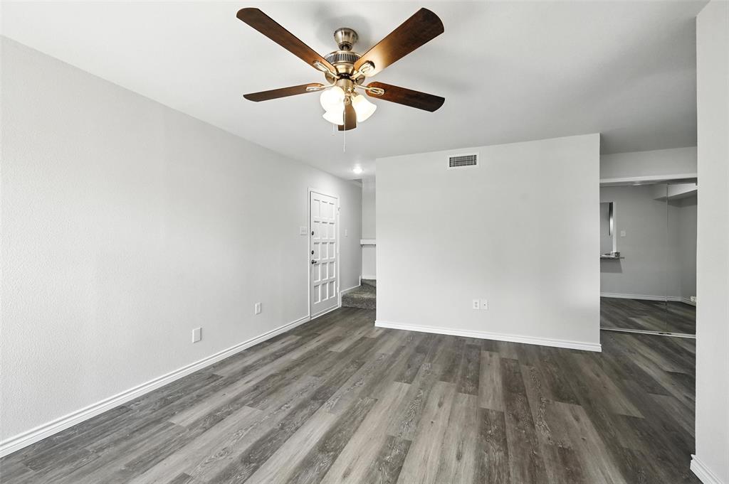 5626 Preston Oaks Road, Unit 22C Dallas, TX 75254 - Photo 12 of 29 an empty room with wooden floor ceiling fan and windows