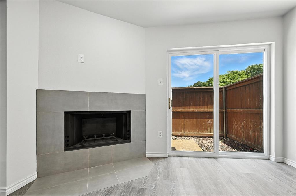 5626 Preston Oaks Road, Unit 22C Dallas, TX 75254 - Photo 17 of 29 a living room with a fireplace and a wooden floor