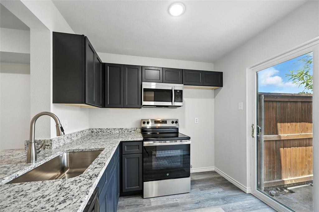 5626 Preston Oaks Road, Unit 22C Dallas, TX 75254 - Photo 7 of 29 a kitchen with stainless steel appliances kitchen island granite countertop a stove and a sink