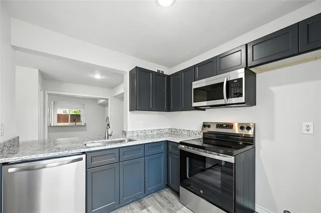a kitchen with stainless steel appliances a stove microwave and sink