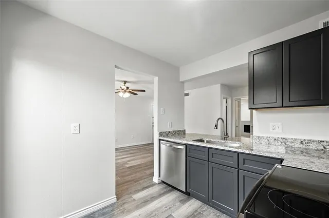 a kitchen with a sink cabinets and wooden floor