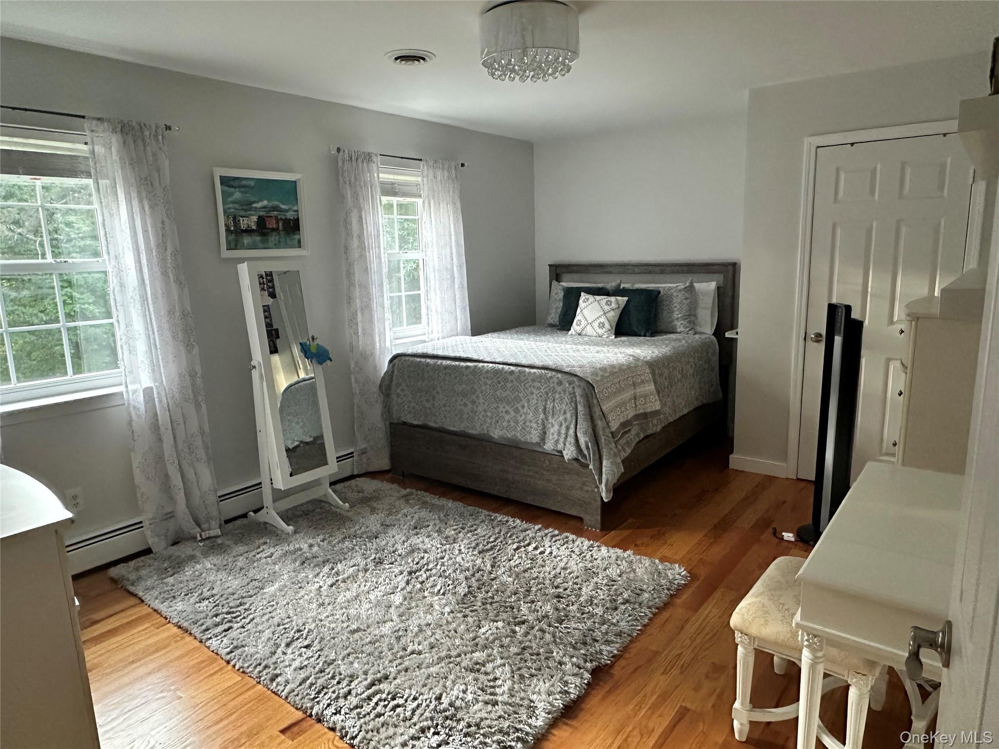 95 Weed Road Pine Bush, NY 12566 - Photo 16 of 31 Hardwood flooring throughout this second bedroom featuring a ceiling-mounted light fixture, two windows, and a paneled door