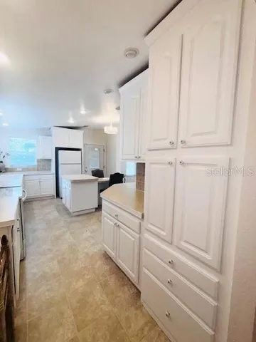 a kitchen with white cabinets and white appliances