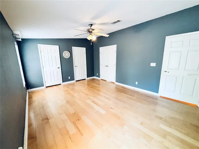 a view of an empty room with a refrigerator and a window