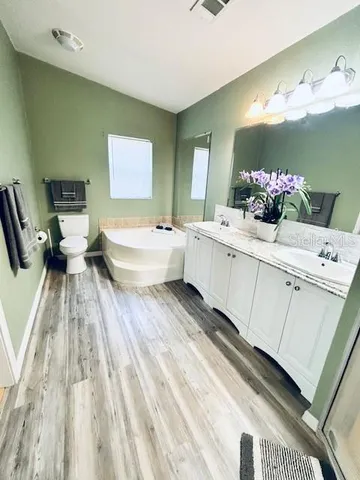 a spacious bathroom with a bathtub sink and mirror