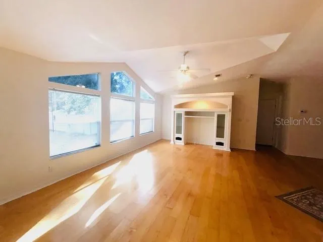 a view of an empty room with a window and fireplace