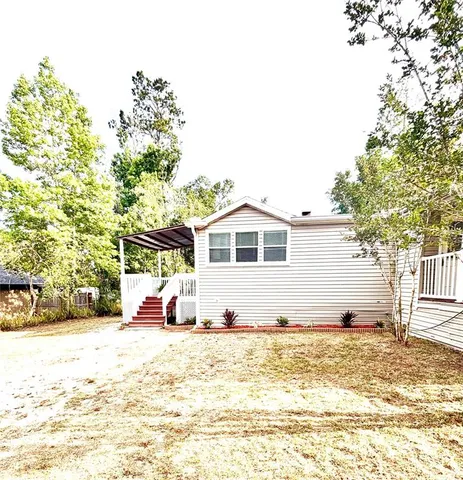 a view of a white house with a yard
