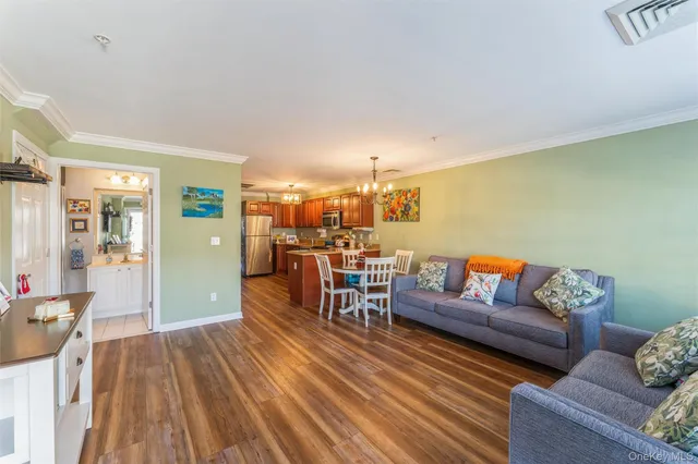 a kitchen with stainless steel appliances granite countertop wooden cabinets a refrigerator a stove a sink and a wooden floors