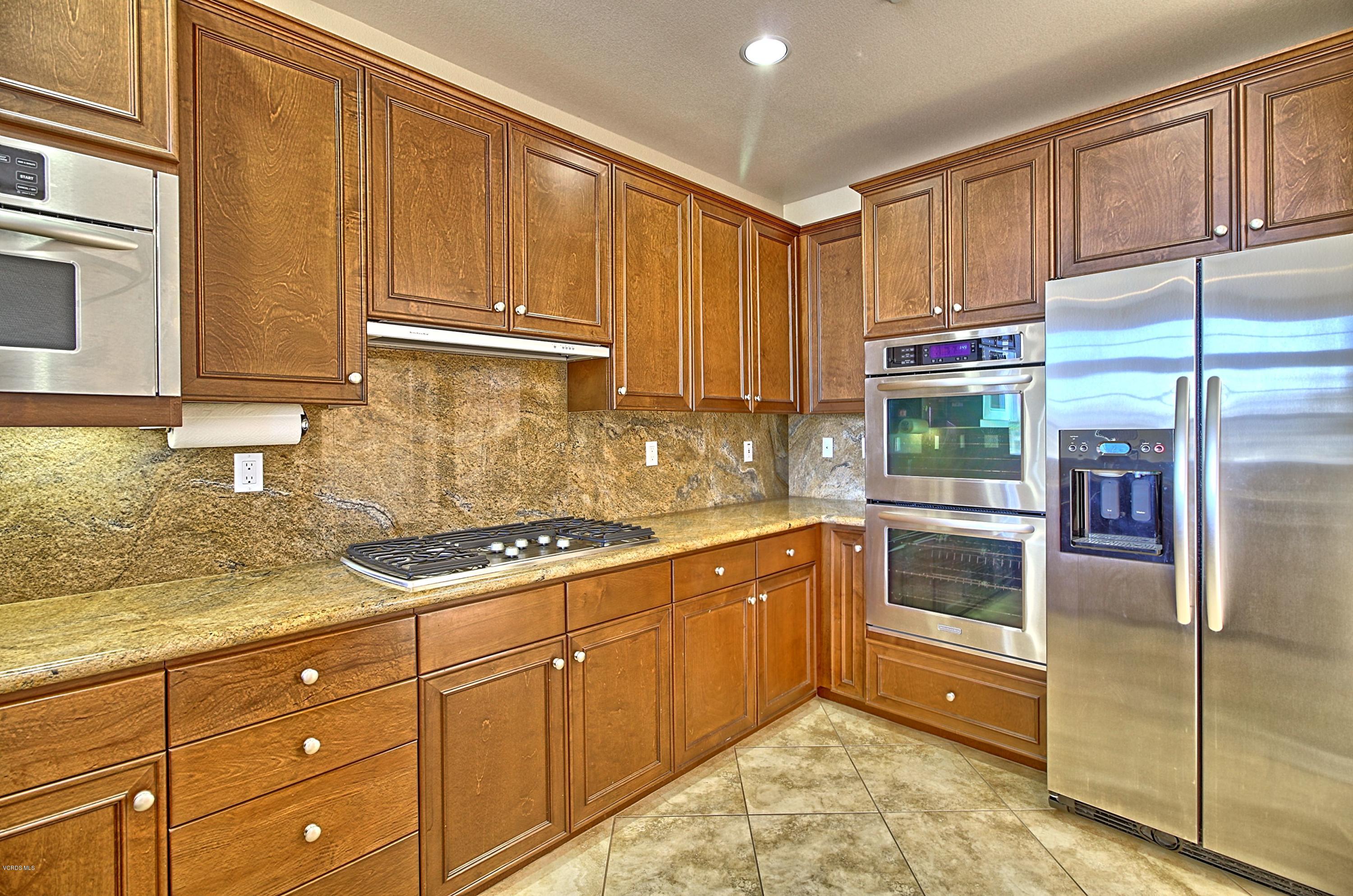 1568 Seabridge Lane Oxnard, CA 93035 - Photo 16 of 33 a kitchen with stainless steel appliances granite countertop a refrigerator a stove and a sink with wooden cabinets