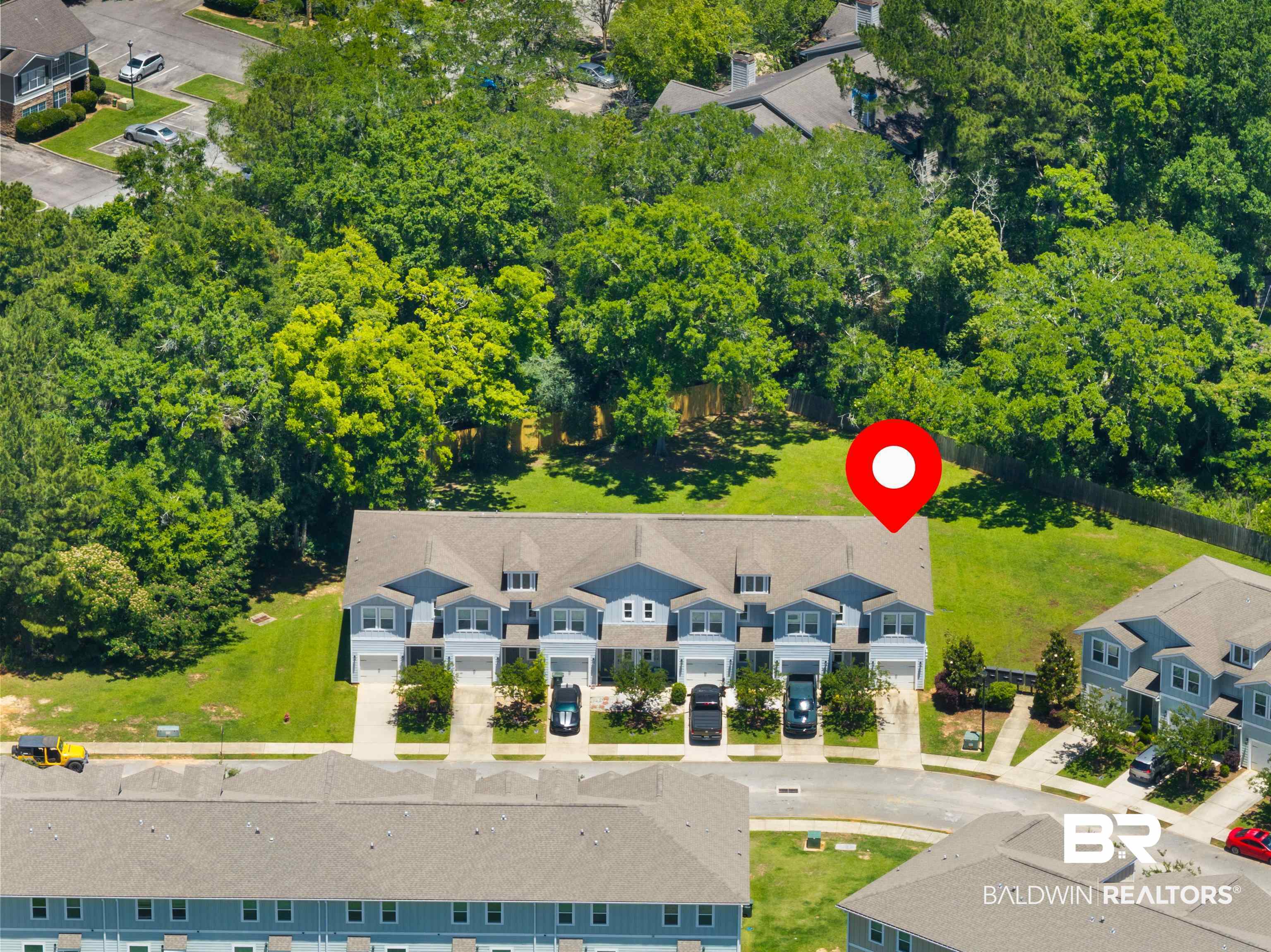 25806 Pollard Road, Unit 6 Daphne, AL 36526 - Photo 37 of 38 Row of townhomes featuring light blue siding, white trim, and individual garages