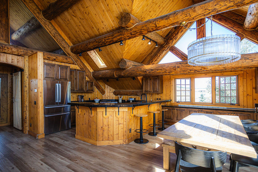 2335 County Road Placerville, CO 81430 - Photo 18 of 38 a view of a dining room with furniture wooden floor and a kitchen