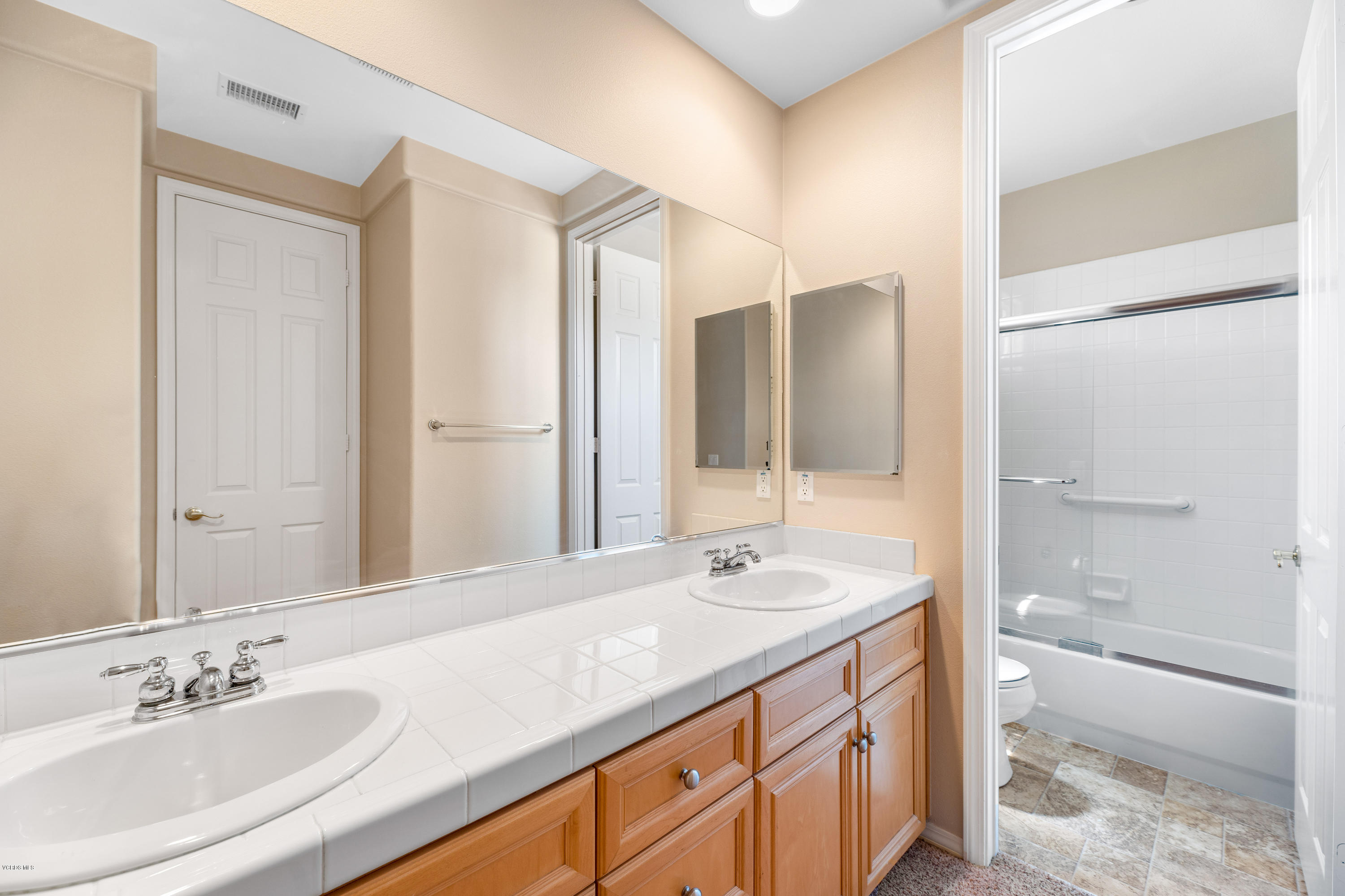 4591 Bluewood Court Moorpark, CA 93021 - Photo 19 of 43 a bathroom with a granite countertop sink mirror and a bathtub