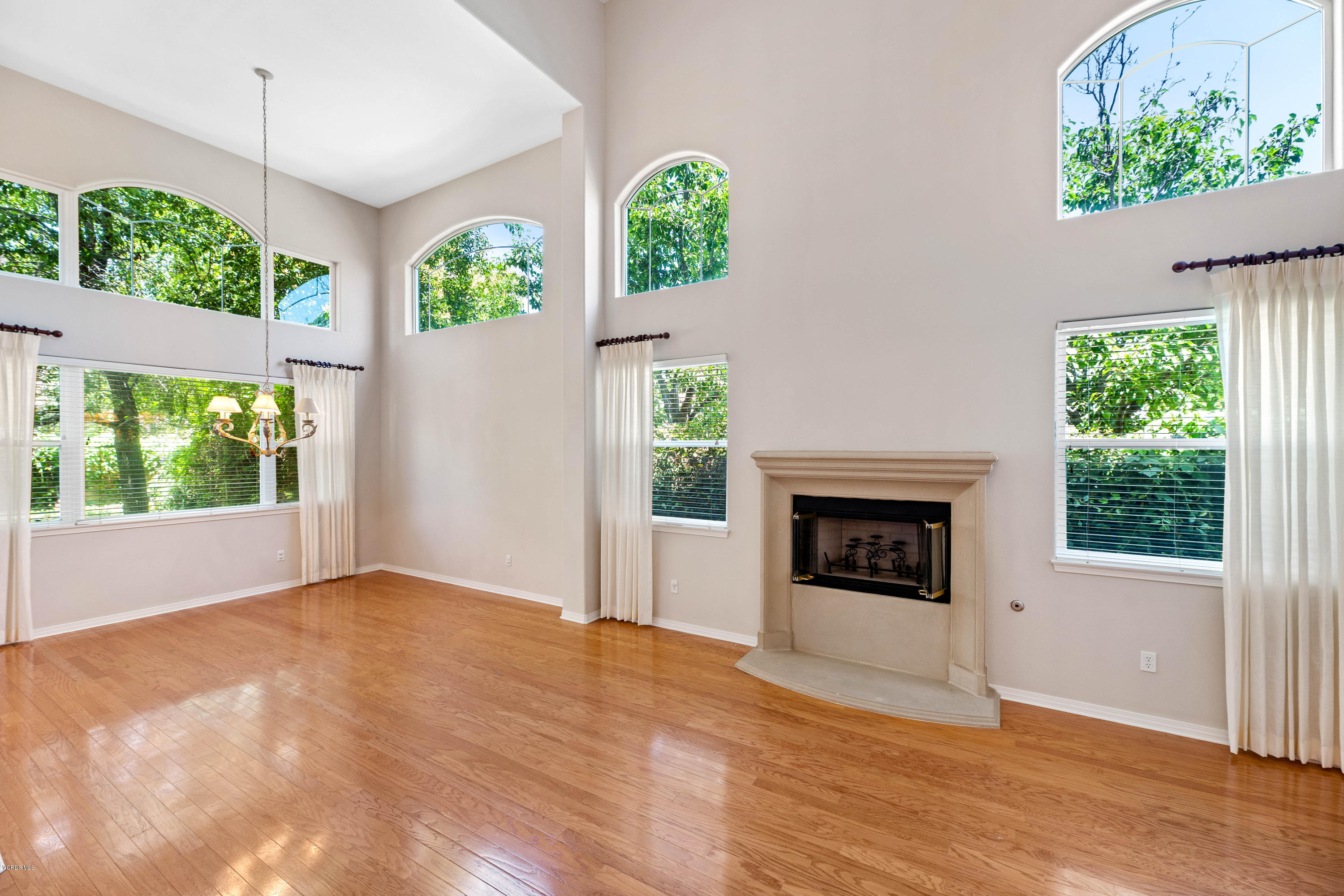 4591 Bluewood Court Moorpark, CA 93021 - Photo 6 of 43 a view of an empty room with wooden floor windows and a fireplace