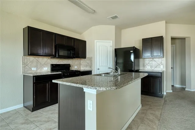 a kitchen with stainless steel appliances granite countertop a sink and a stove