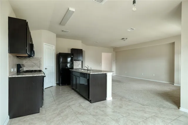 a kitchen with stainless steel appliances granite countertop a refrigerator and a stove