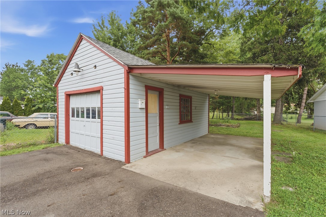 311 Fowles Road Berea, OH 44017 - Photo 33 of 40 Detached garage with a single vehicle bay, featuring a white paneled door with upper window inserts, and light blue horizontal siding