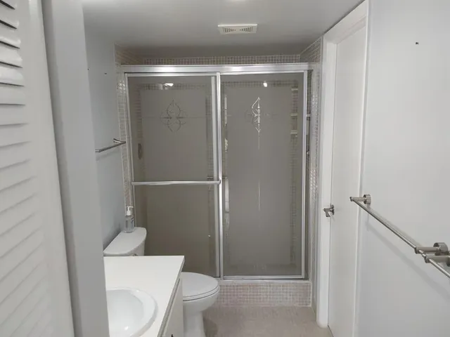 a bathroom with a shower a toilet and sink