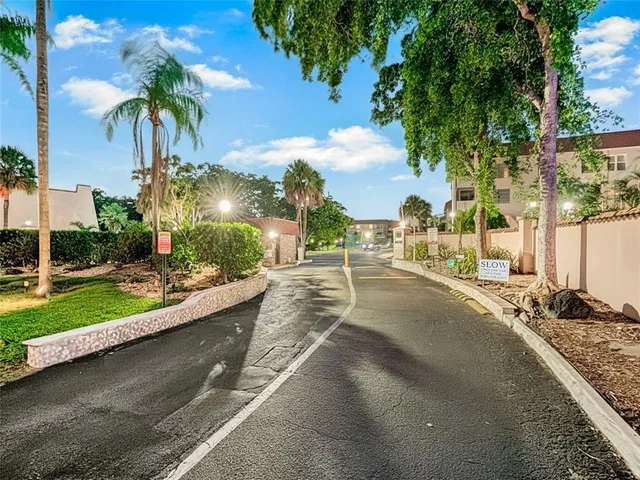a view of a house with a yard and palm trees