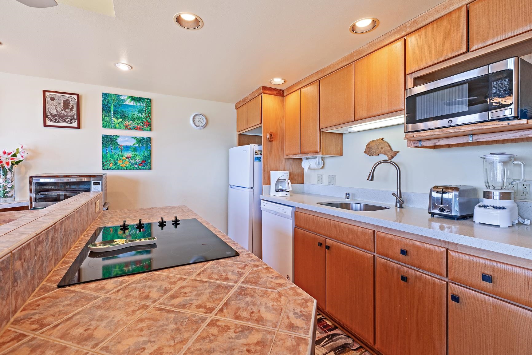 3559 Lower Honoapiilani Road, Unit 5G Lahaina, HI 96761 - Photo 13 of 42 a kitchen with kitchen island granite countertop a sink and white cabinets