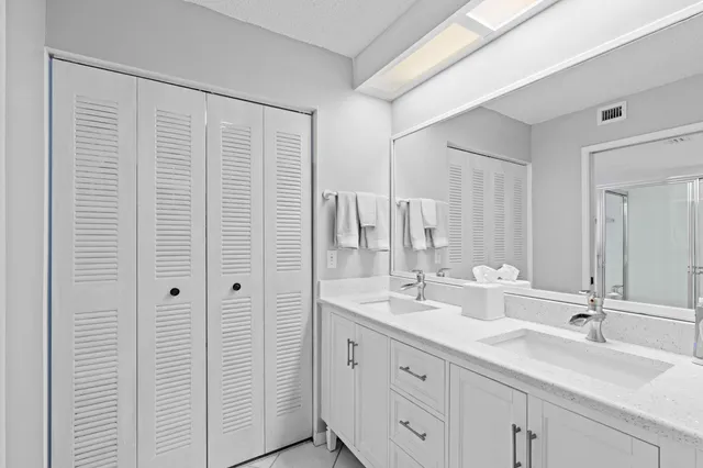 a bathroom with double vanity sink and a mirror