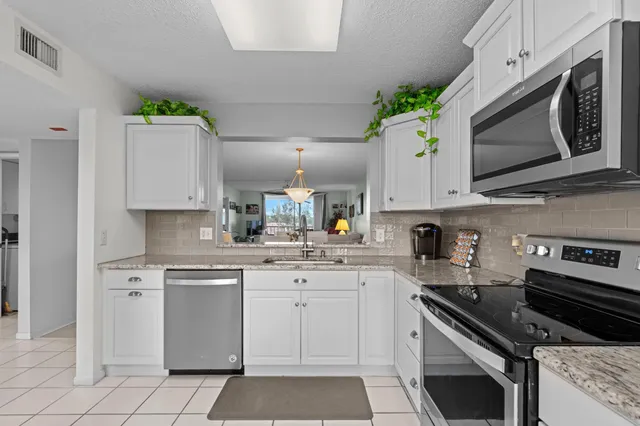 a kitchen with cabinets stainless steel appliances and a wooden floor