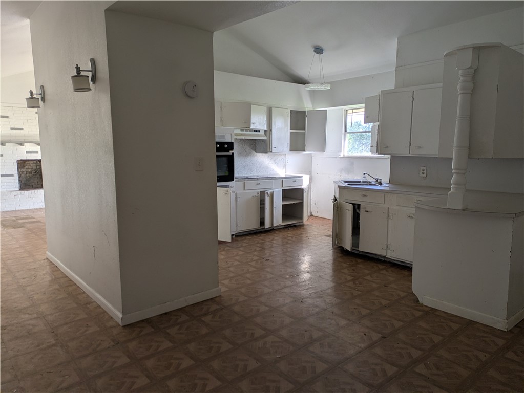 124 Redwood Drive Mathis, TX 78368 - Photo 5 of 10 a kitchen with cabinets and white stainless steel appliances