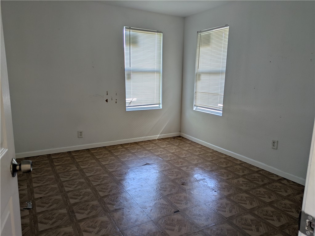 124 Redwood Drive Mathis, TX 78368 - Photo 6 of 10 an empty room with wooden floor and windows