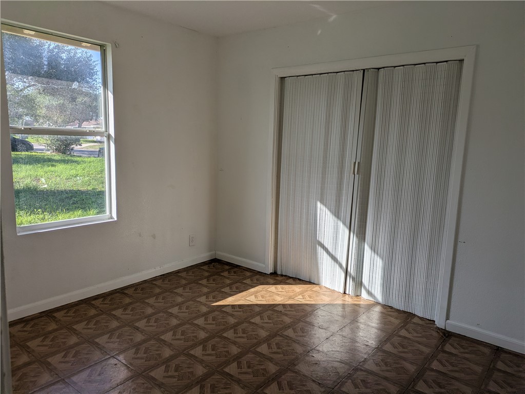 124 Redwood Drive Mathis, TX 78368 - Photo 10 of 10 a view of an empty room with wooden floor and a window