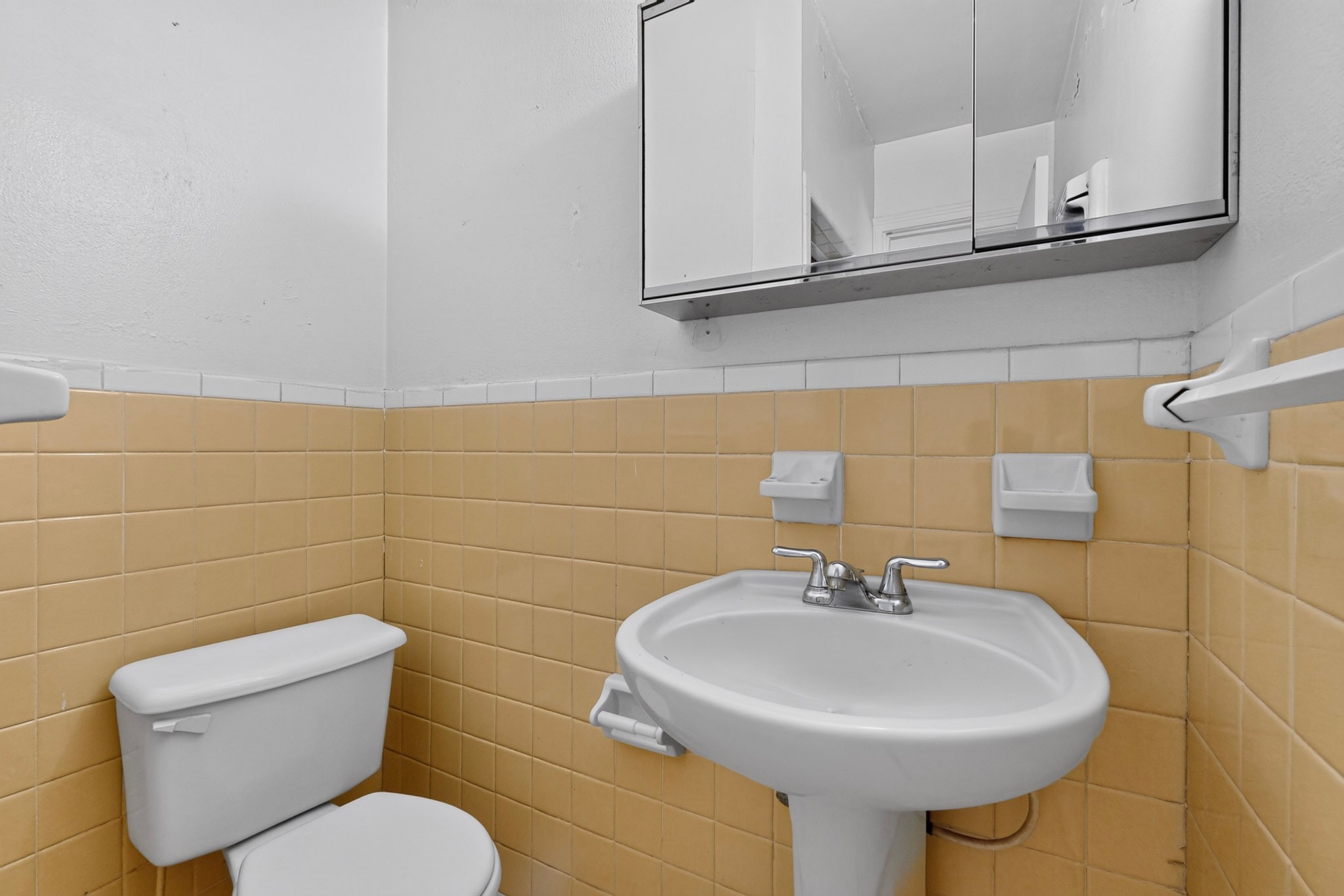 4703 Leslie Avenue Austin, TX 78721 - Photo 20 of 34 Functional bathroom with tiled walls and a classic pedestal sink, offering everyday convenience.