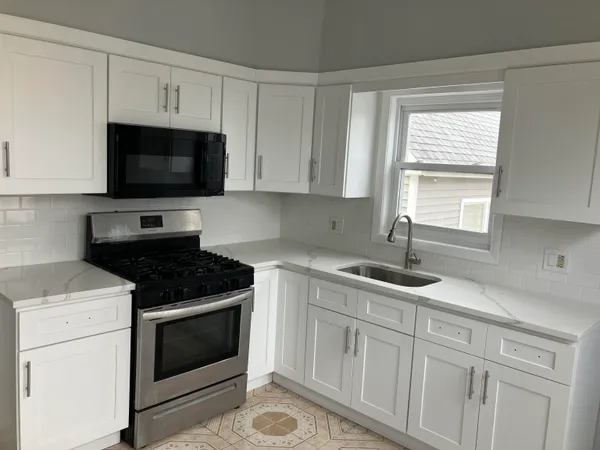 a kitchen with appliances a sink and a stove