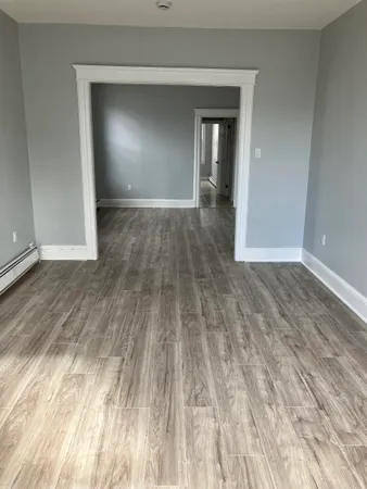 a view of a room with wooden floor and a window
