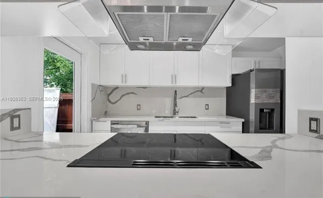 a kitchen with kitchen island granite countertop a sink a counter and a stove