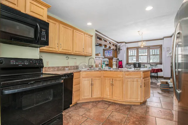a kitchen with stainless steel appliances granite countertop a stove top oven a sink dishwasher and a microwave oven on the blue kitchen countertops