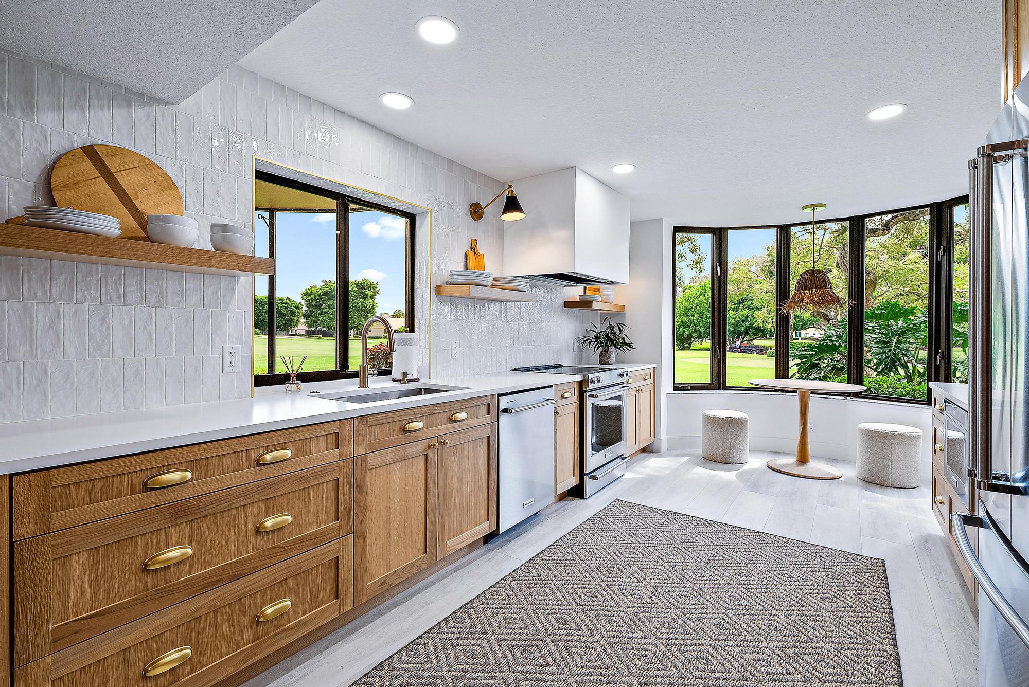 a open kitchen with stainless steel appliances granite countertop a stove a sink and a granite counter tops with white cabinets