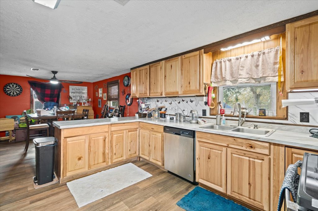 250 Rick Road La Grange, TX 78945 - Photo 22 of 27 a kitchen with stainless steel appliances granite countertop a stove top oven a sink dishwasher and cabinets with wooden floor