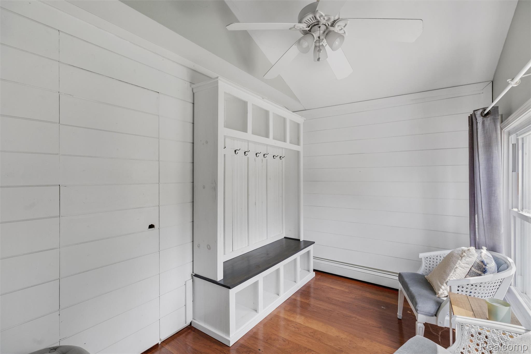 415 Leon Road Walled Lake, MI 48390 - Photo 4 of 47 Built-in mudroom bench with storage cubbies and coat hooks, set against horizontal plank walls