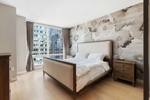 a large bed sitting in a bedroom next to a window