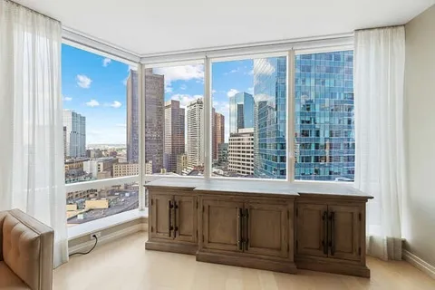 a living room with a large window and walk in closet