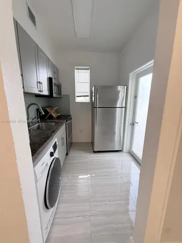 a view of a kitchen with refrigerator and washer