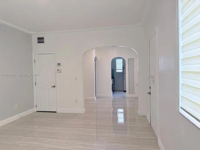 a view of a hallway with wooden floor and glass door