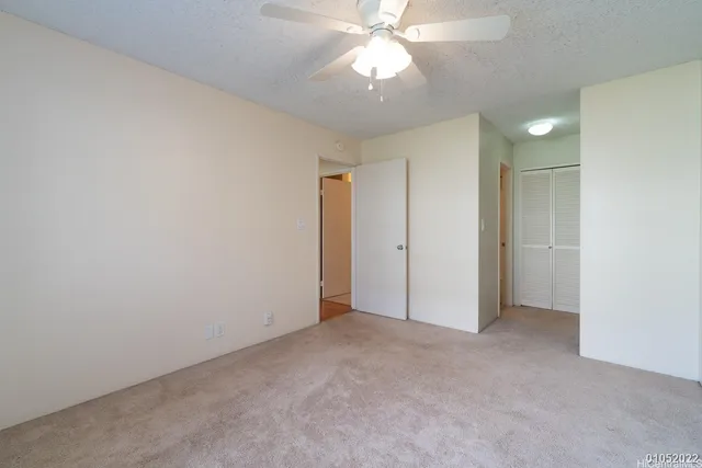 an empty room with a ceiling fan and a fan