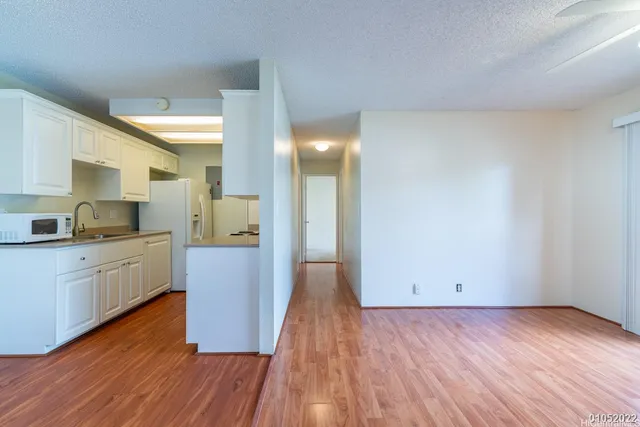 a kitchen with wooden floors and white cabinets