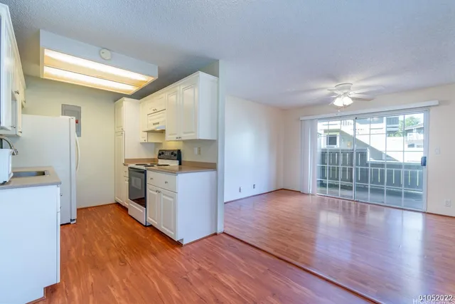 a kitchen with granite countertop a stove a sink and a refrigerator