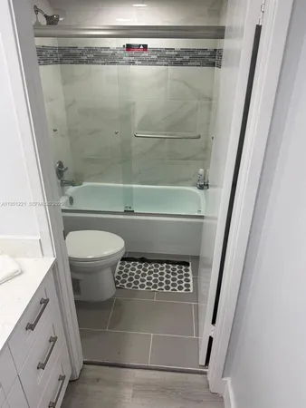 a bathroom with a shower a toilet and a sink