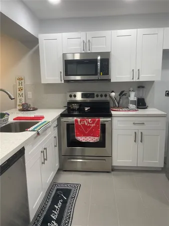 a kitchen with stainless steel appliances a stove a microwave and cabinets