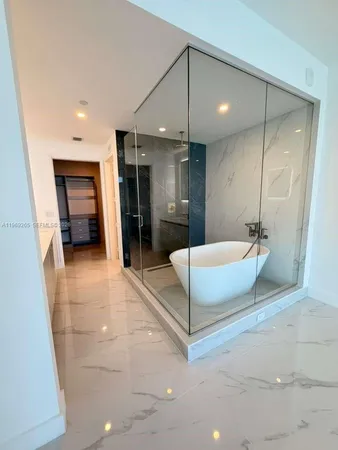 a spacious bathroom with a tub a sink and a mirror