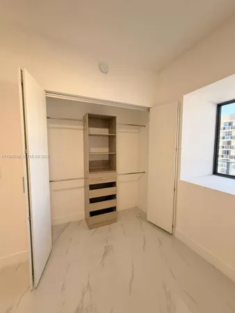 a view of walk in closet with empty racks